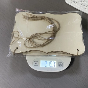 DIY unfinished wooden hanging tags set with twine shown on scale for precise weight measurement