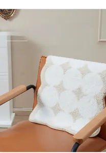 Close-up of thick plush geometric rug on chair showing soft shaggy texture and cream tones