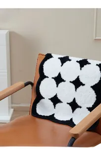 Close-up of fluffy black and white geometric patterned cake fleece rug with star motifs