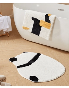Plush bathroom mat set with geometric patterns on wooden floor next to bathtub