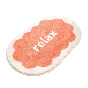 Absorbent cream-style bathroom mat with wavy edges and relax text on orange surface