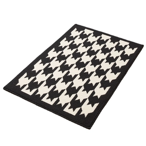 Non-slip rectangular polypropylene indoor mat with classic black and white houndstooth pattern