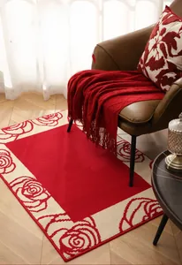 Macro detail of the woven texture and red rose vine pattern on the thick festive floor mat