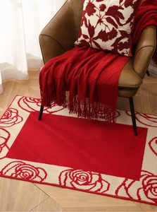 Detailed texture of red festive floral rug with roses and cream geometric patterns