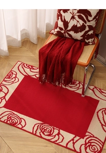 Macro view of red rose pattern entryway rug on light wood herringbone flooring