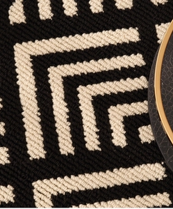 Macro shot of black and white geometric tufted rug texture with dense woven details