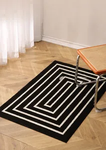 Detailed view of modern geometric spiral pattern on durable black and white door mat
