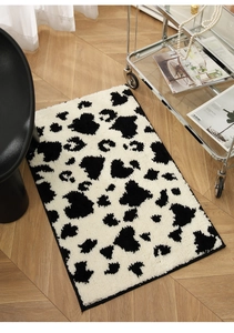 Detail of plush cow print rug on wood floor with modern furniture for bedroom decor