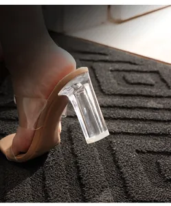 Detailed side view of clear PVC mule sandals featuring a transparent acrylic block heel