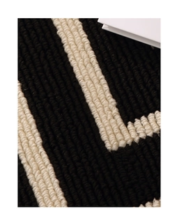 Detailed macro view of black and white geometric striped loop pile texture on home doormat