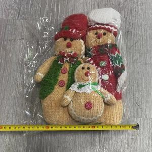 Three-piece gingerbread gnome plush set measured on a tape for sizing reference
