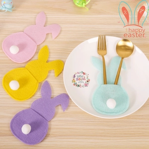 Easter bunny-shaped cutlery holders in four pastel colors on a wooden dining table