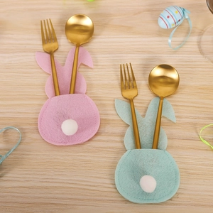 Close-up of rabbit-shaped felt cutlery holders with pompom details for Easter table setting