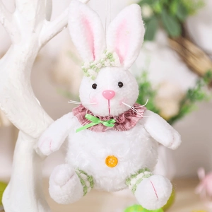 Detail of white plush Easter bunny with pink ears, green bow and orange button