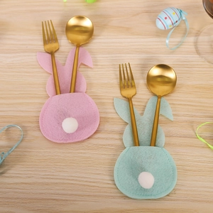 Easter rabbit felt cutlery holder sets in pink and blue on a light wood background