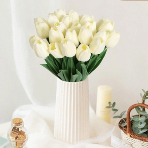 Detailed view of cream white artificial tulips in a white ribbed ceramic vase for home decor