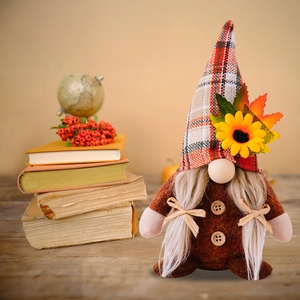 Detailed view of fall gnome plush decoration with sunflower and maple leaf on plaid hat