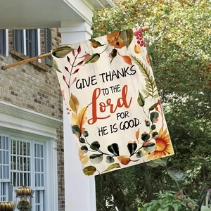 Close-up of linen garden flag with autumn maple leaves and religious text on wooden pole