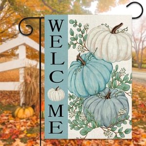 Close-up of double-sided linen garden flag with pumpkins and welcome text in fall garden