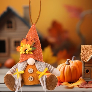 Detail of fall gnome ornament with orange knit hat, sunflower, and maple leaf decorations