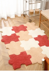 Close-up of interlocking puzzle plush carpet in red and beige on a wooden floor