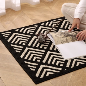 Washable entryway mat with vintage black and white geometric checkered patterns on wood floor