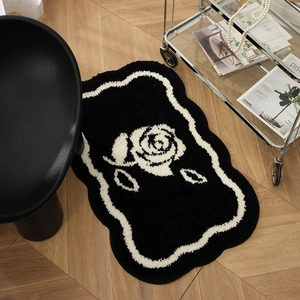 Zwart-witte rozen pluche badmat met golvende randen op een lichte houten vloer