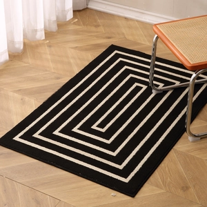 Modern geometric black and white rectangular entryway rug on a wooden floor