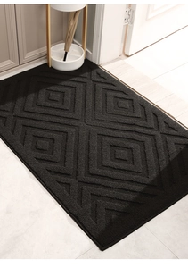 Macro detail of black entry mat featuring a textured geometric 3D square pattern