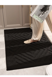 Detailed texture of black rectangular entryway rug with geometric diamond pattern
