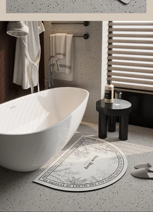 Detail of semi-circular diatom mud bath mat with elegant botanical line art and text