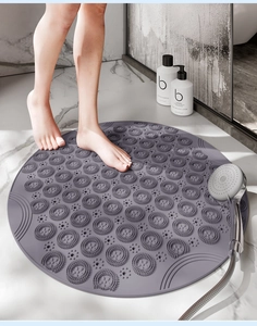 Detailed view of grey round shower mat with massage bristles and non-slip surface