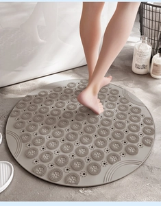 Macro detail of grey anti-slip round bathroom mat with massage texture and drain holes