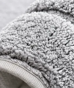 Close-up of thick grey absorbent bathroom mat with non-slip texture and durable edges