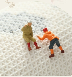Macro detail of miniature hiker figurines on a white textured landscape scenery
