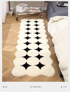 Close-up of cream scalloped runner rug with black diamond pattern and plush texture