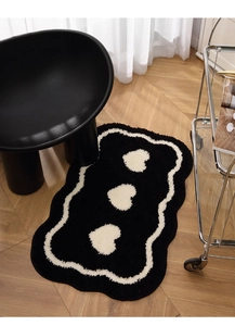 Close-up of heart pattern tufted rug with soft texture and irregular wavy edges