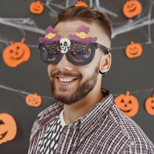 Halloween-Brille mit lila Hexenhüten und Totenkopf-Deko getragen von lächelndem Model