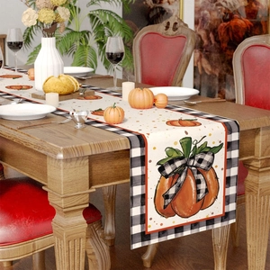 Detail view of cotton linen table runner with pumpkin patterns and black white plaid edges