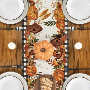 Flat lay of Thanksgiving table runner with pumpkin and maple leaf prints on wood