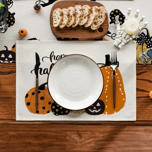 Close-up of Halloween table mat featuring pumpkin prints and festive decor on wood