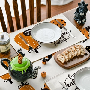 Close-up of Halloween table runner and placemats with pumpkins and Happy Halloween text