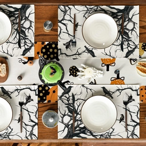 Top-down view of a Halloween table runner set featuring pumpkin and raven motifs on wood
