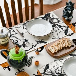 Gothic style Halloween table runner with black trees and crows on rustic wood dining table