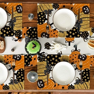 Close-up of Halloween table runner and placemats with orange pumpkin and jack-o-lantern patterns