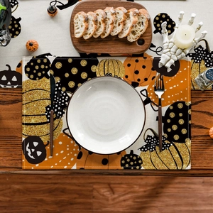 Detailed overhead view of a festive Halloween table mat with orange pumpkin prints