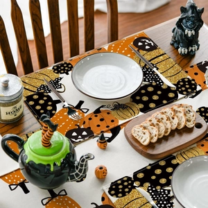 Detail of Halloween table runner and placemat set with pumpkin print on wood table