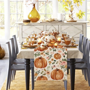 Close-up of Thanksgiving table runner with orange pumpkin and floral print on linen fabric