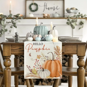 Detail of a beige linen table runner featuring pumpkins and HELLO Pumpkin typography