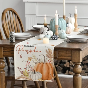 Detail of Hello Pumpkin table runner with orange pumpkins and red berries on wood table